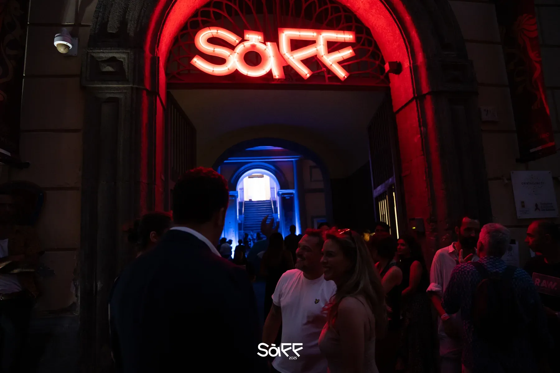 L'insegna al neon del SàFF sopra l'arco d'ingresso, con il pubblico che entra